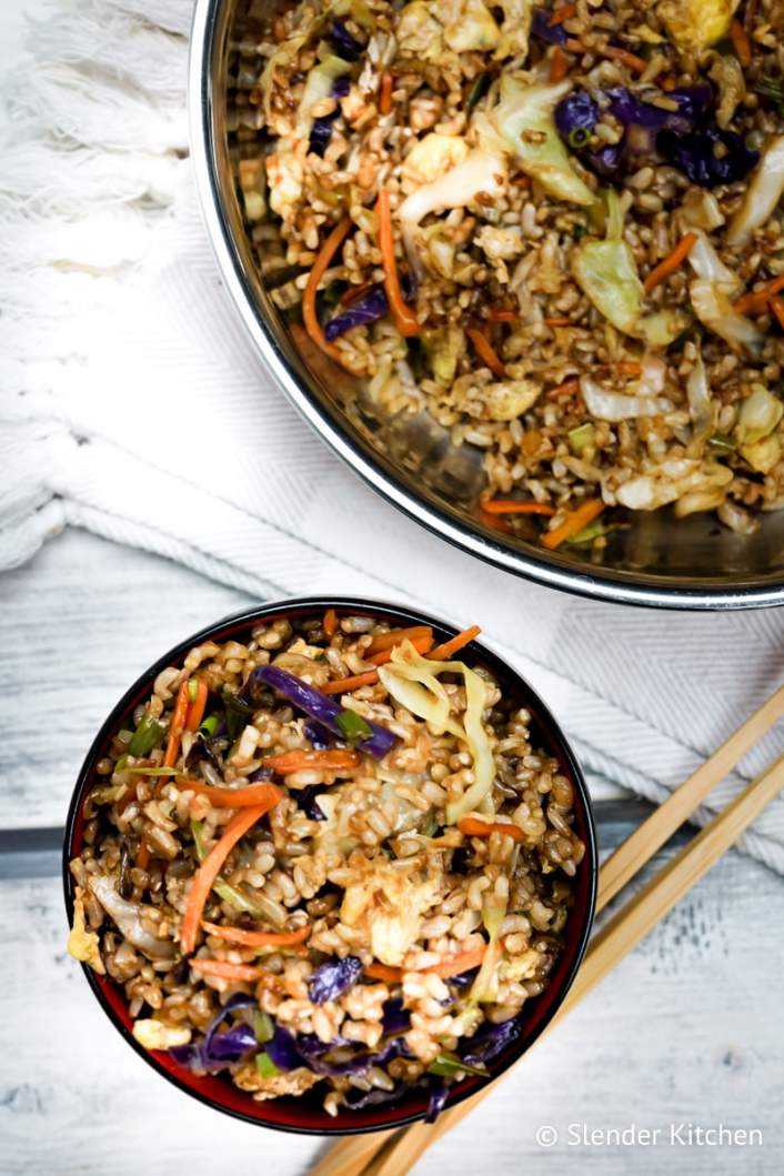 Healthy fried rice served in a small bowl with fresh green onions and chopsticks.