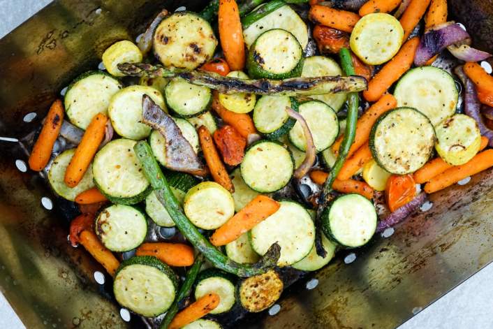 Grilled Vegetables in a grill basket after 15 minutes of cooking.