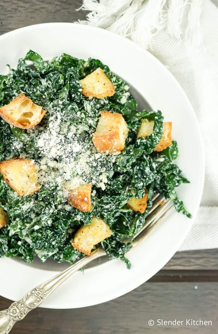 Kale Caesar Salad with parmesan cheese and croutons.