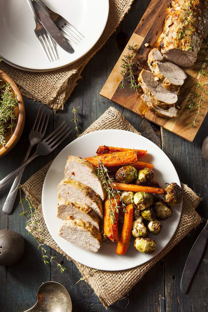 Slow Cooker Maple Pork Tenderloin on a serving plate with rosemary.