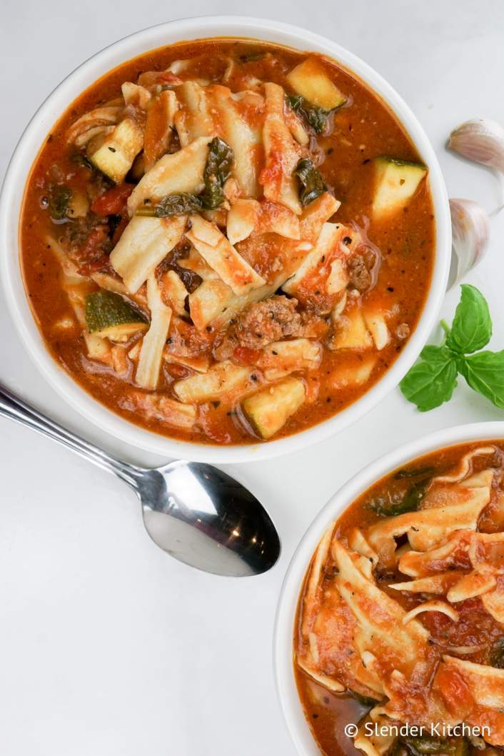 Slow Cooker Vegetarian Lasagna in two bowls with a spoon and mozzarella.