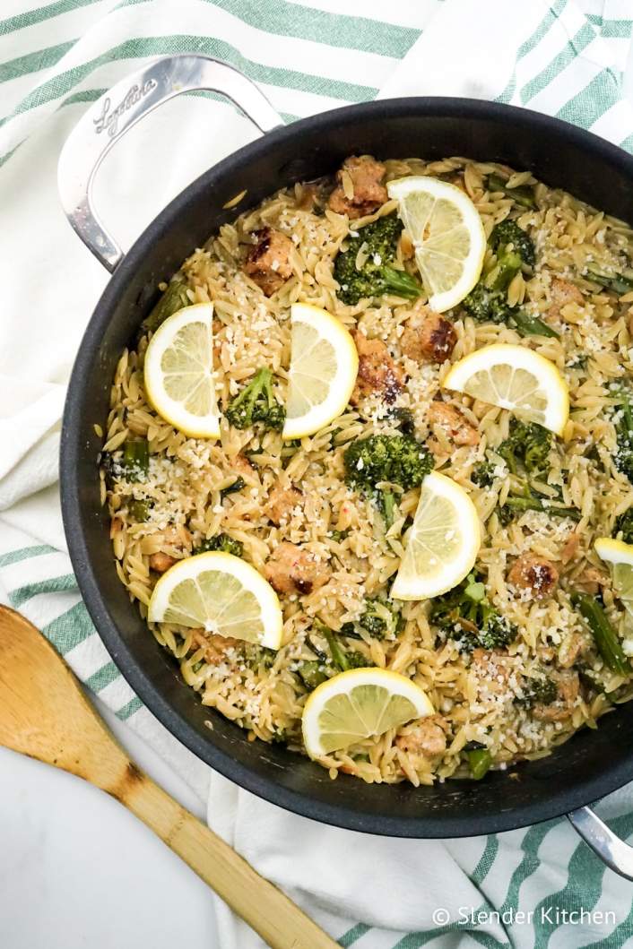 Weight Watchers Lemon Orzo with broccoli and chicken sausage in a pan with wooden spoon.