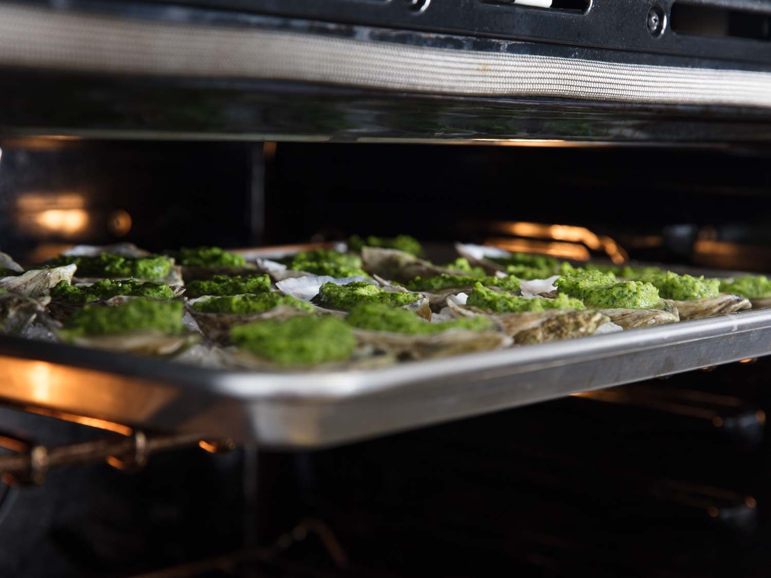 Oysters Rockefeller being placed under broiler.