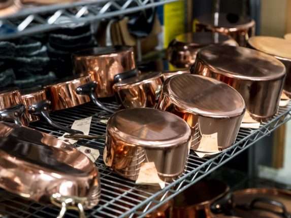 Copper cookware on a shelf