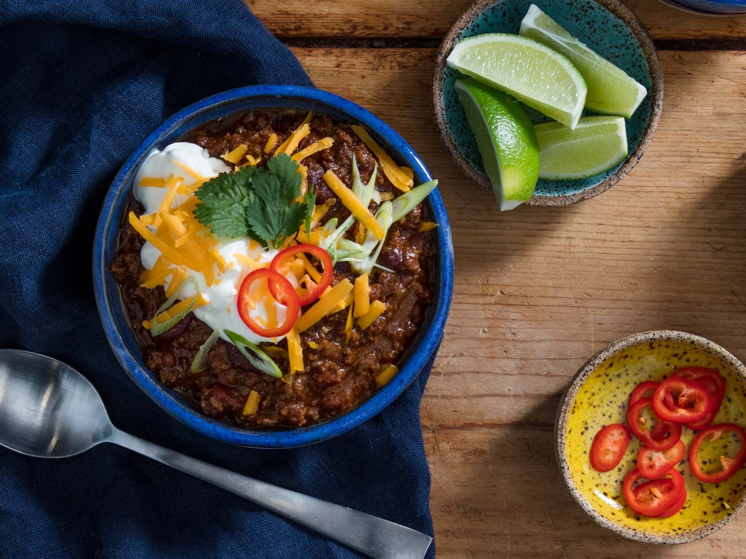 Overhead photo of a bowl of chili with toppings