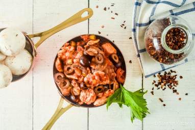 Slow Cooker Chicken Cacciatore with mushrooms and black olives in a copper skillet.