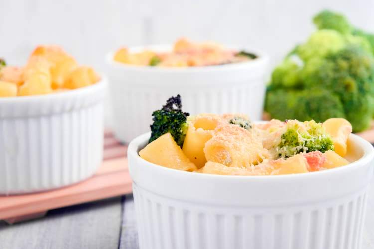 Broccoli mac and cheese in ramekins with pasta, broccoli, and cheese sauce.