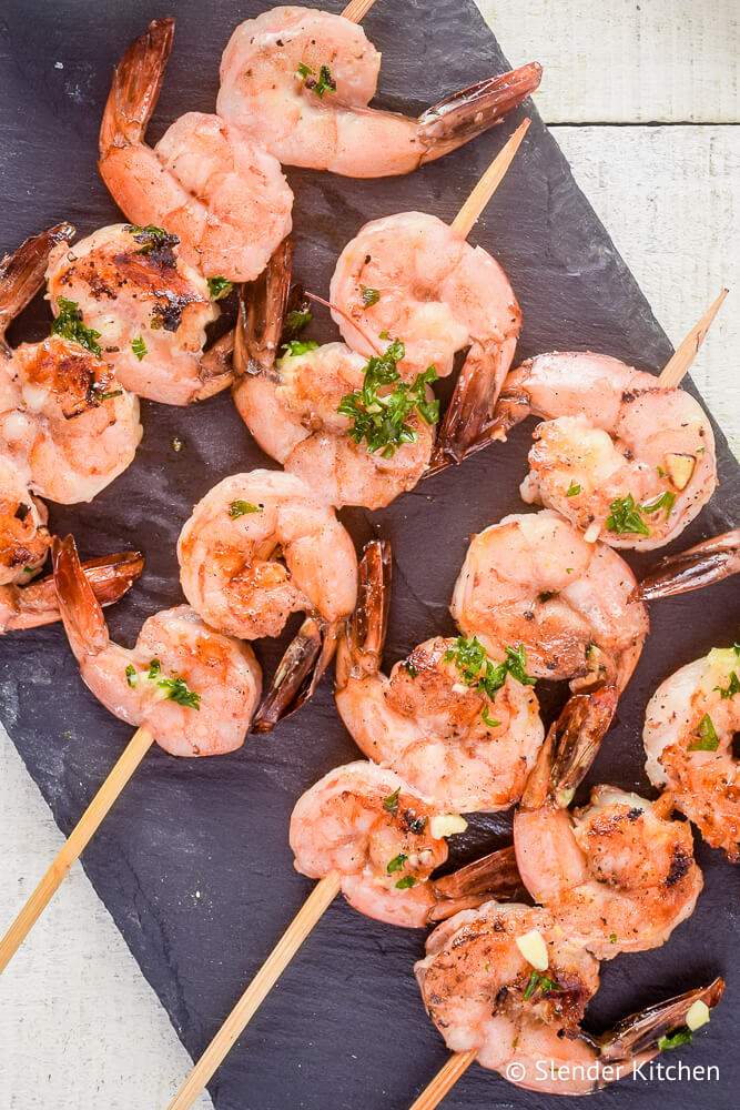 Shrimp kabobs cooked on skewers with lemon, garlic, and parsley.
