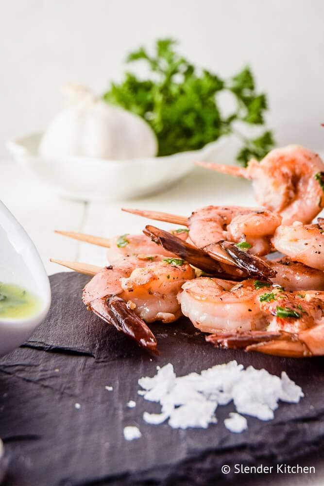 Shrimp kabobs with lemon, garlic, and parsley on skewers.