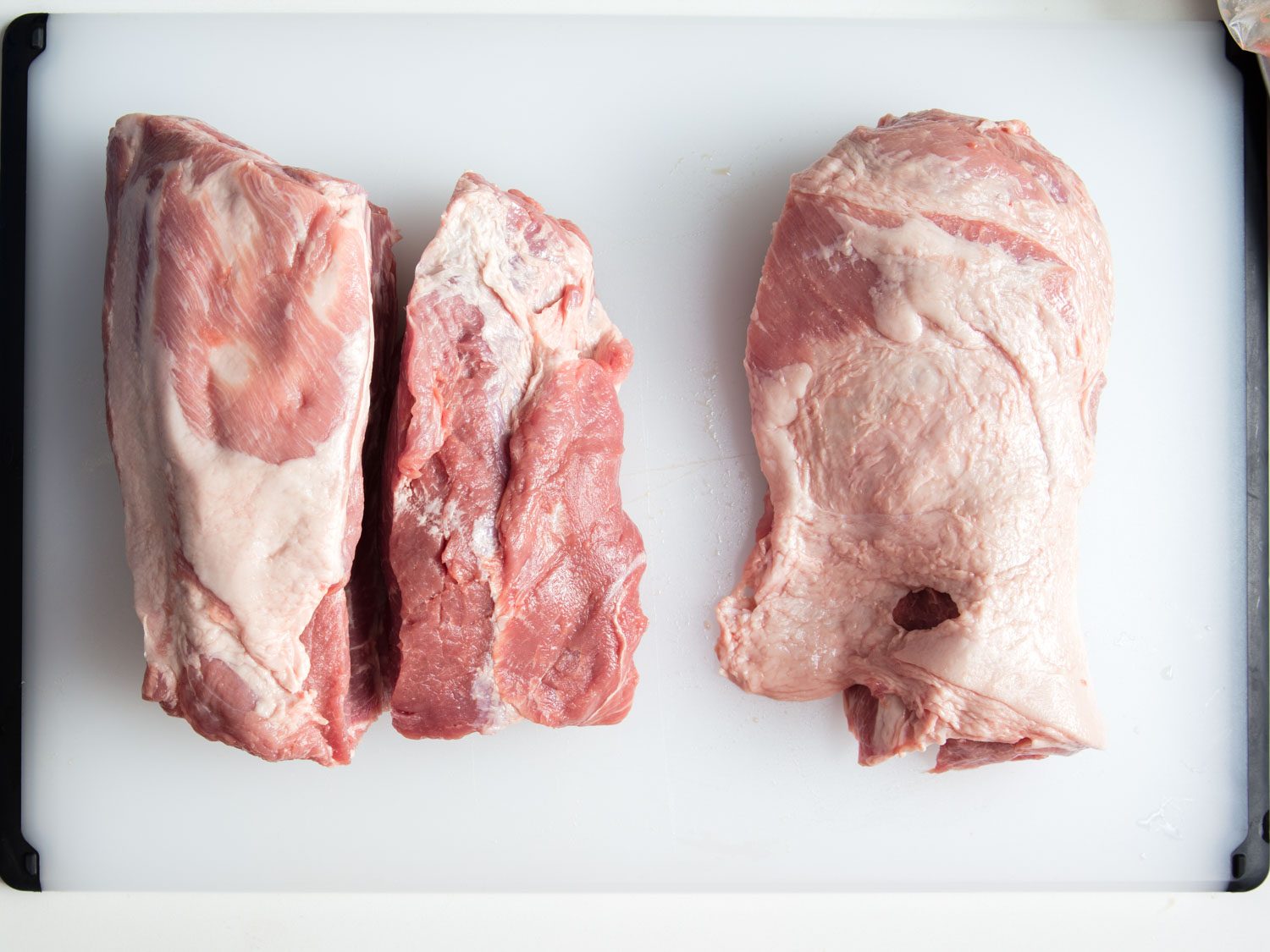 Overhead view of boneless skinless pork shoulder cut into roasts