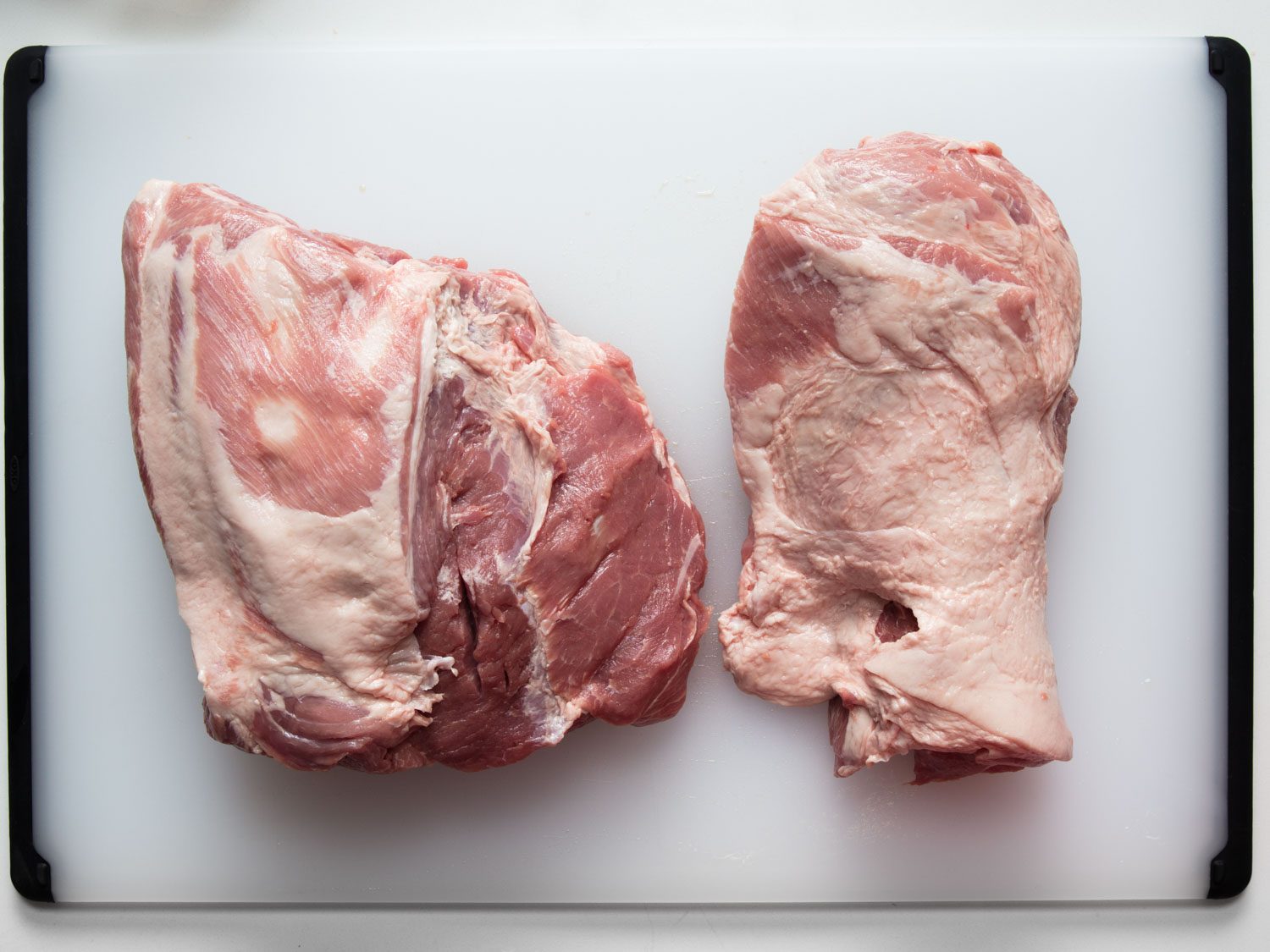 Overhead view of boneless skinless pork shoulder separated into two