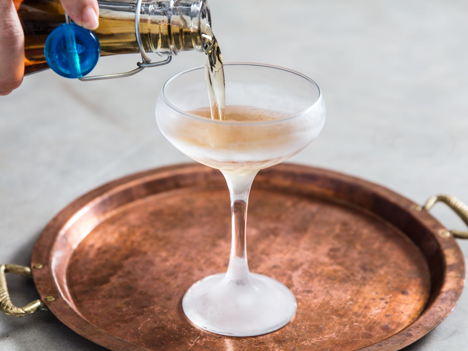 Pouring the Three Piece Suit Cocktail into a chilled coupe glass