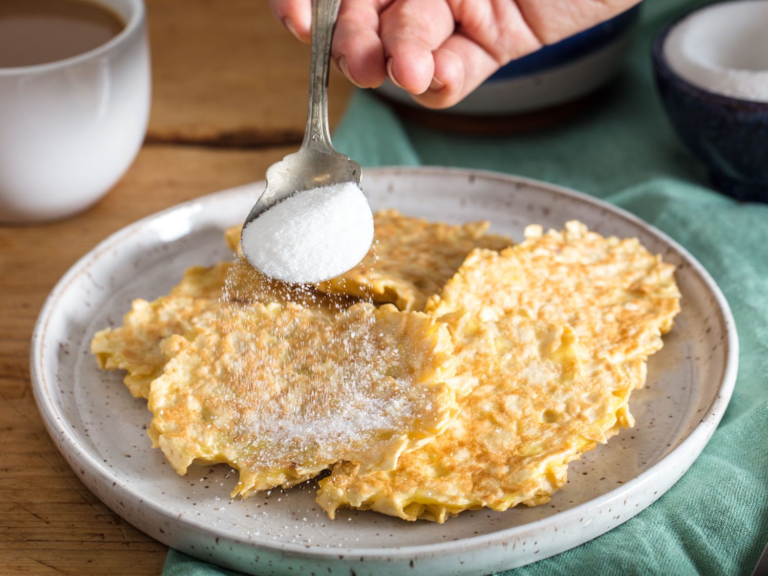 sprinkling matzo brei pancakes with sugar