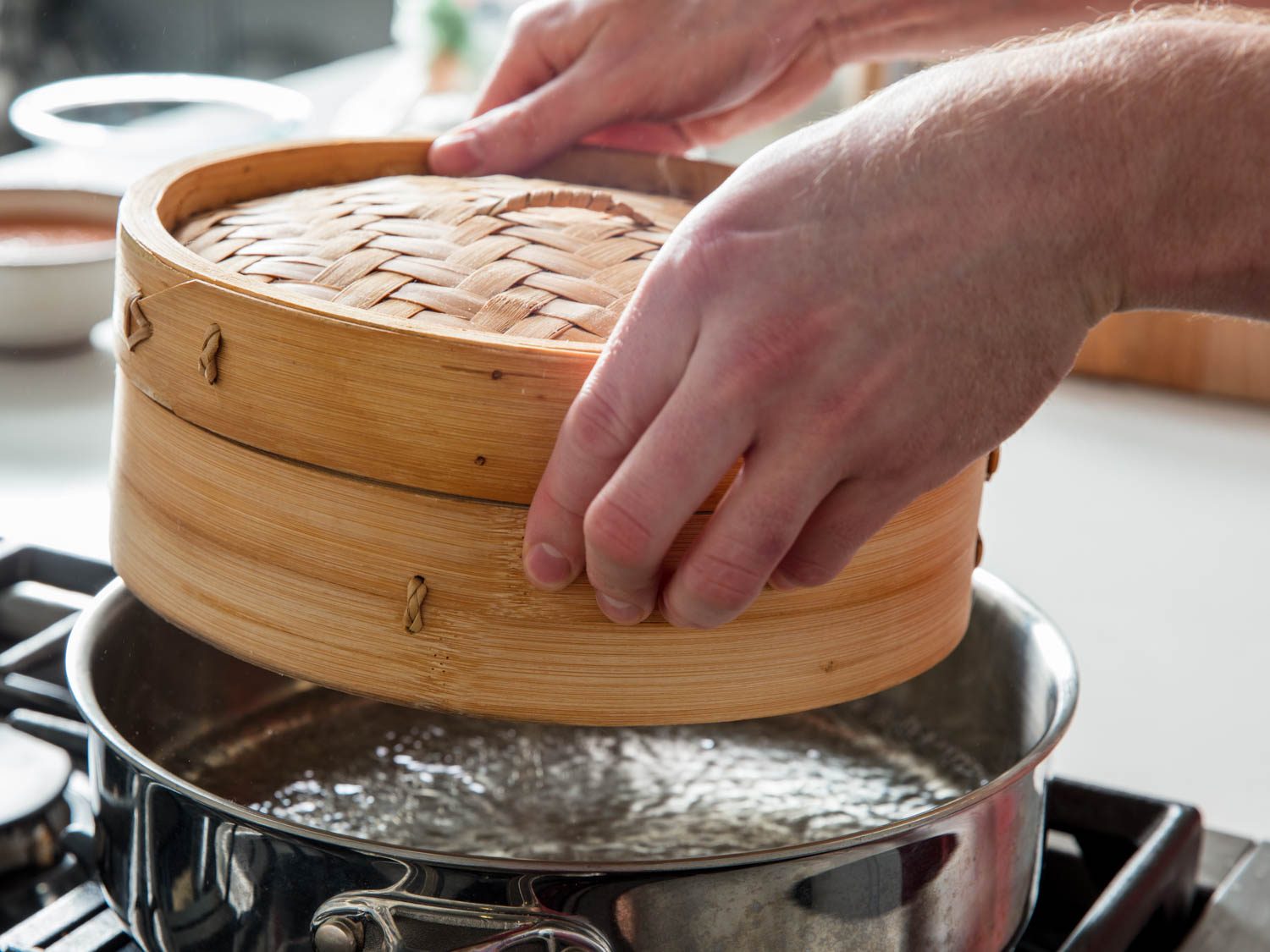 Lifting the steamer basket out of the steaming vessel.