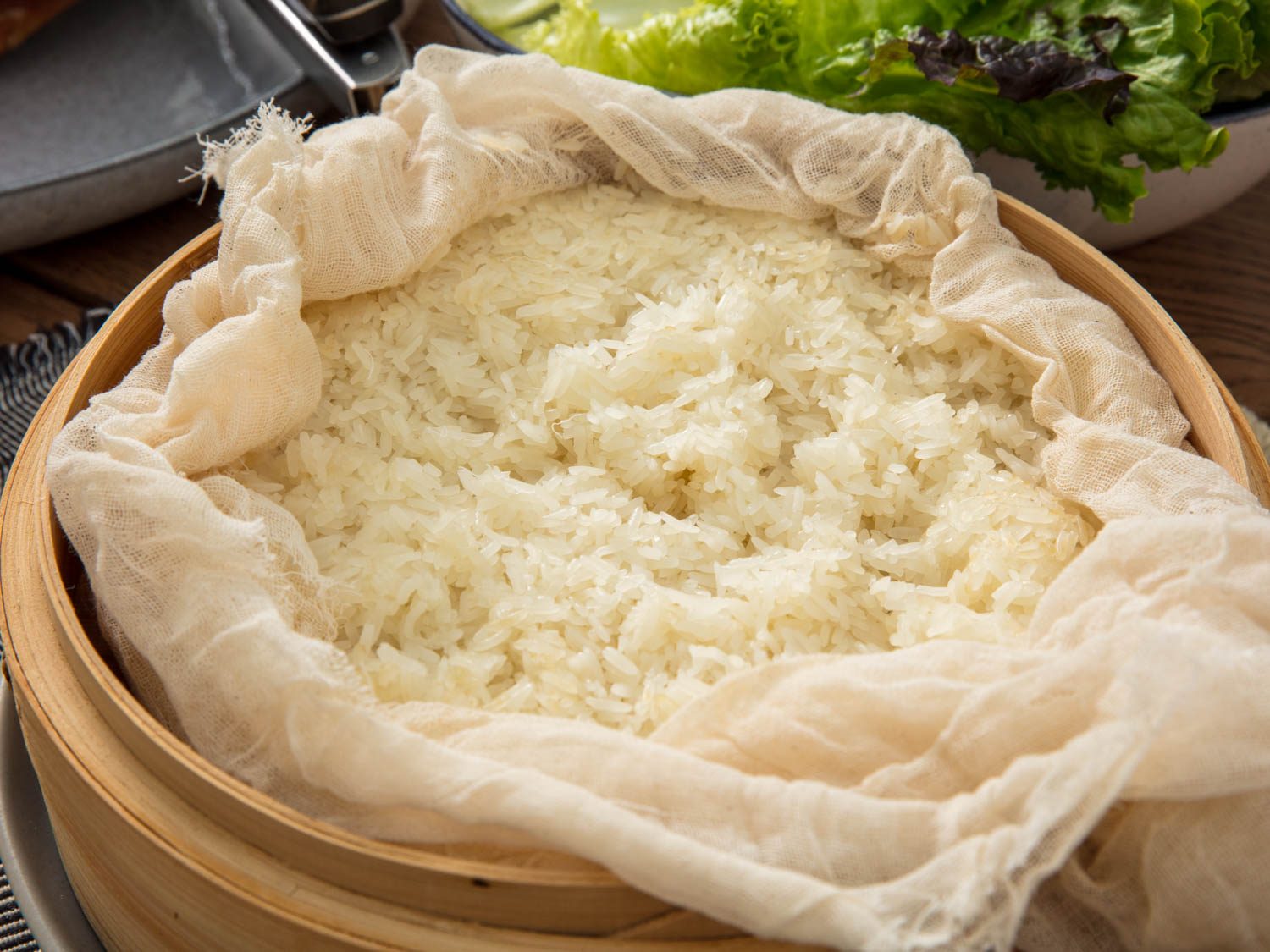 Closeup of finished sticky rice, unwrapped in bamboo steamer basket.