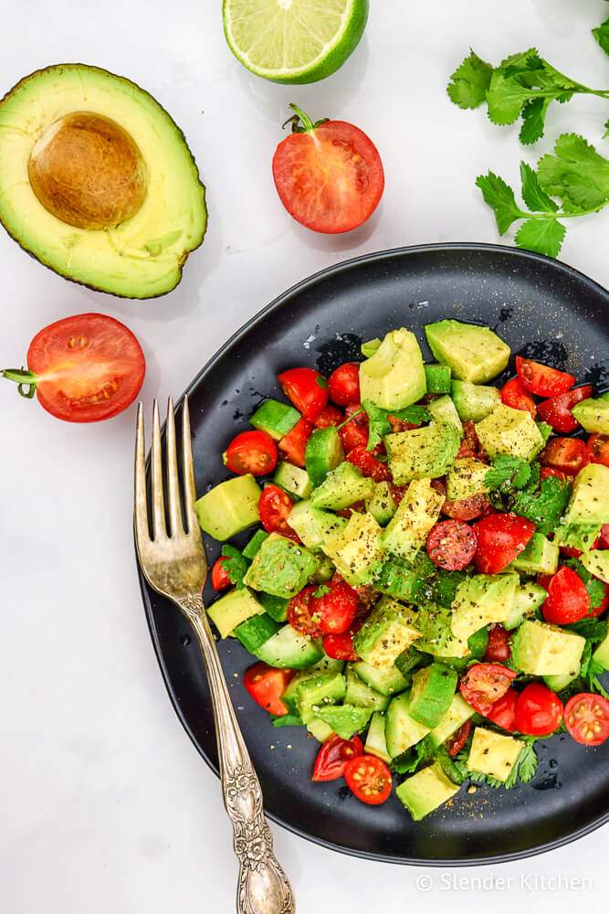 Avocado cucumber salad with tomatoes, lime, salt, and pepper.