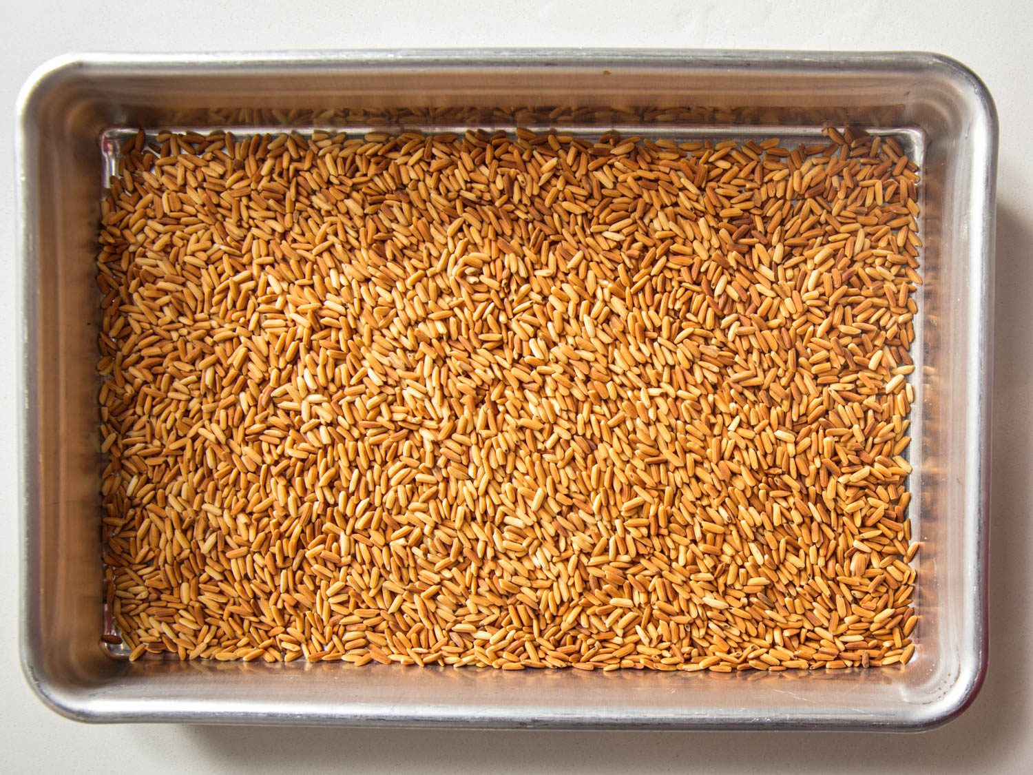 Toasted rice cooling on a small baking sheet.
