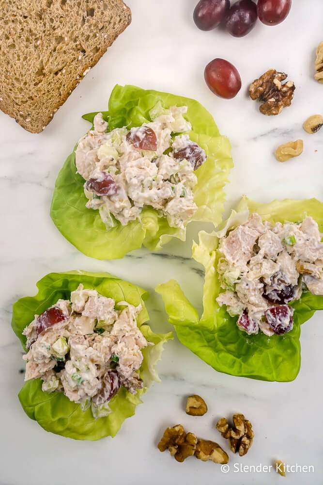 Chicken waldorf salad with grapes, apples, walnuts, and celery in lettuce leaves.