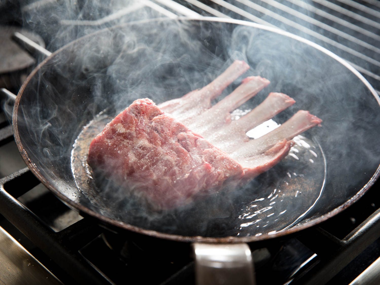 Searing the fat cap on a rack of lamb