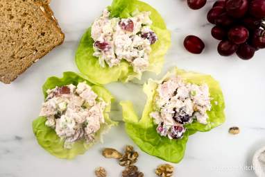 Waldorf chicken salad wrapped in lettuce with grapes, walnuts, and whole wheat bread.