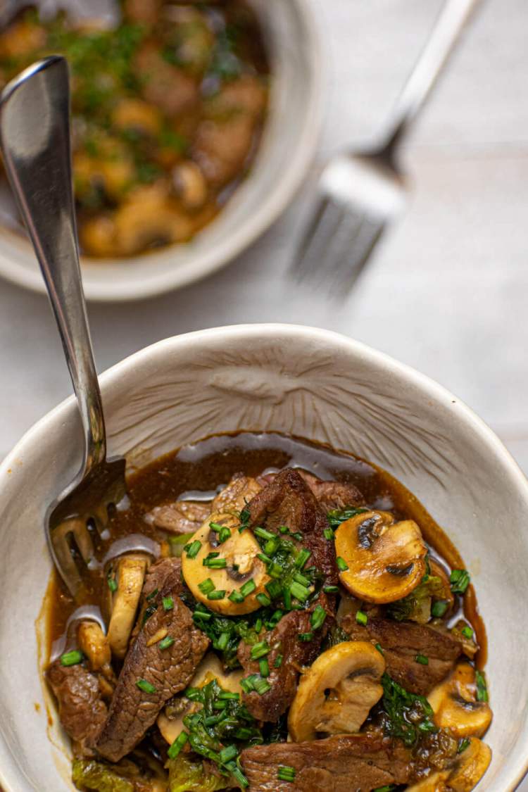 Beef and bok choy stir fry with mushrooms in a soy stir fry sauce in a bowl.