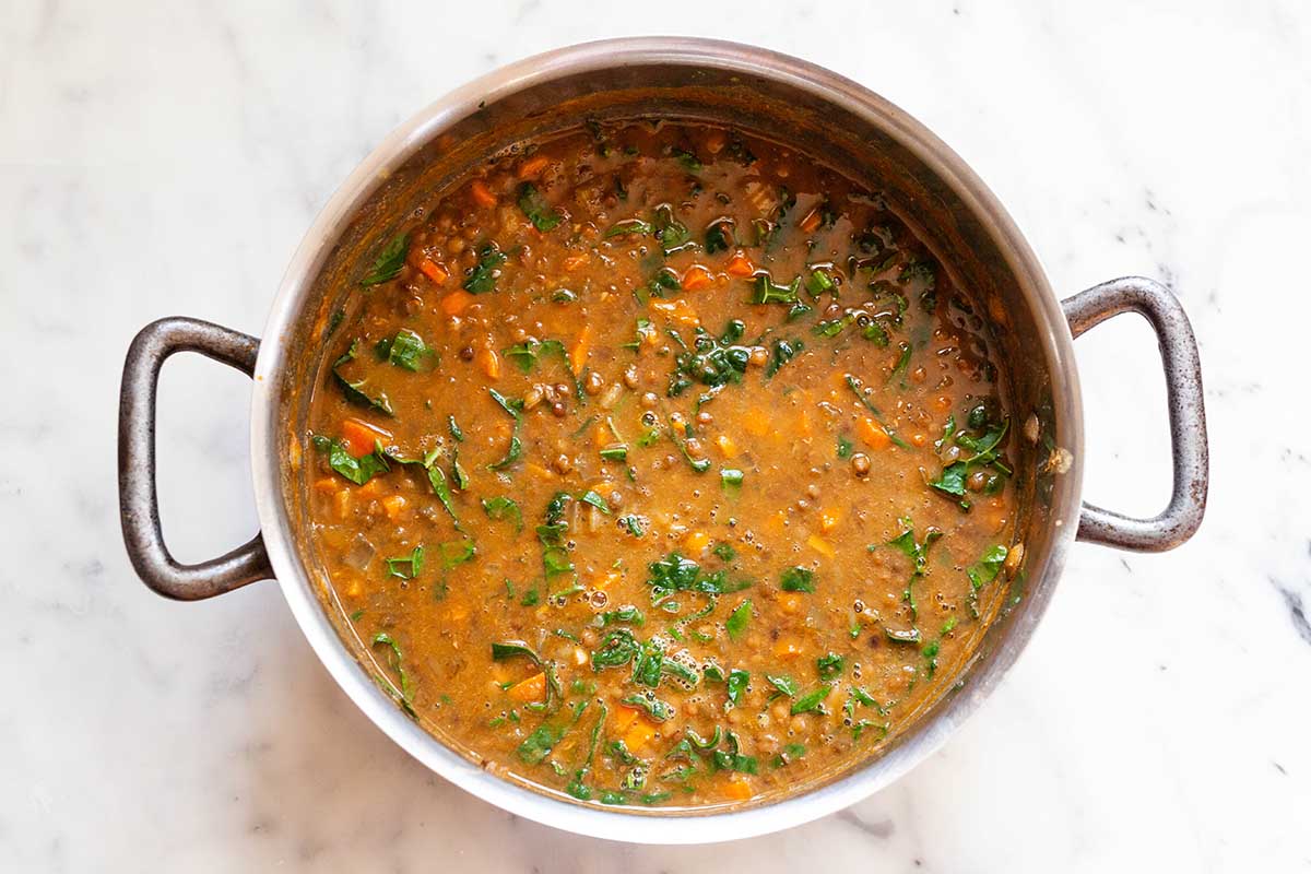 Pot of lentil soup with kale.