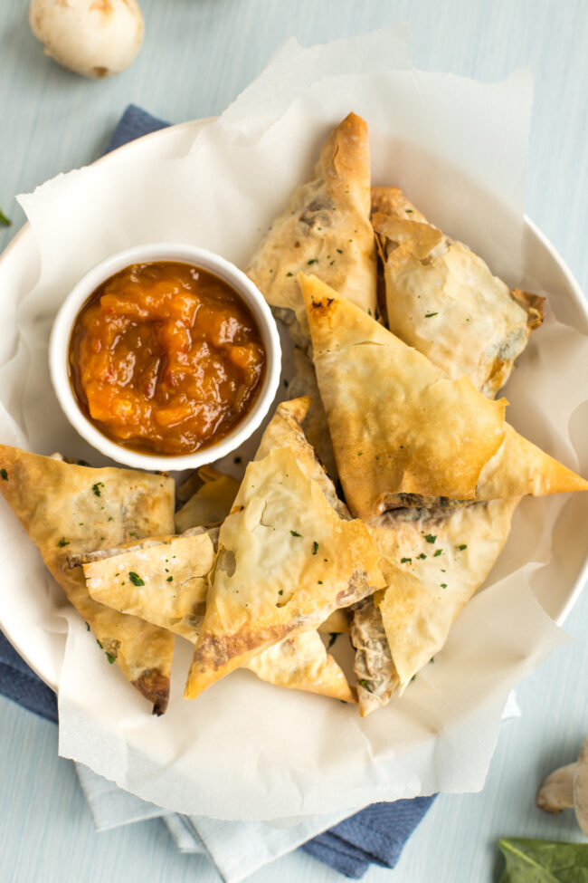 Tofu and spinach samosas with chutney, shot from above.