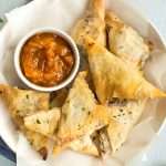 Tofu and spinach samosas with chutney, shot from above.