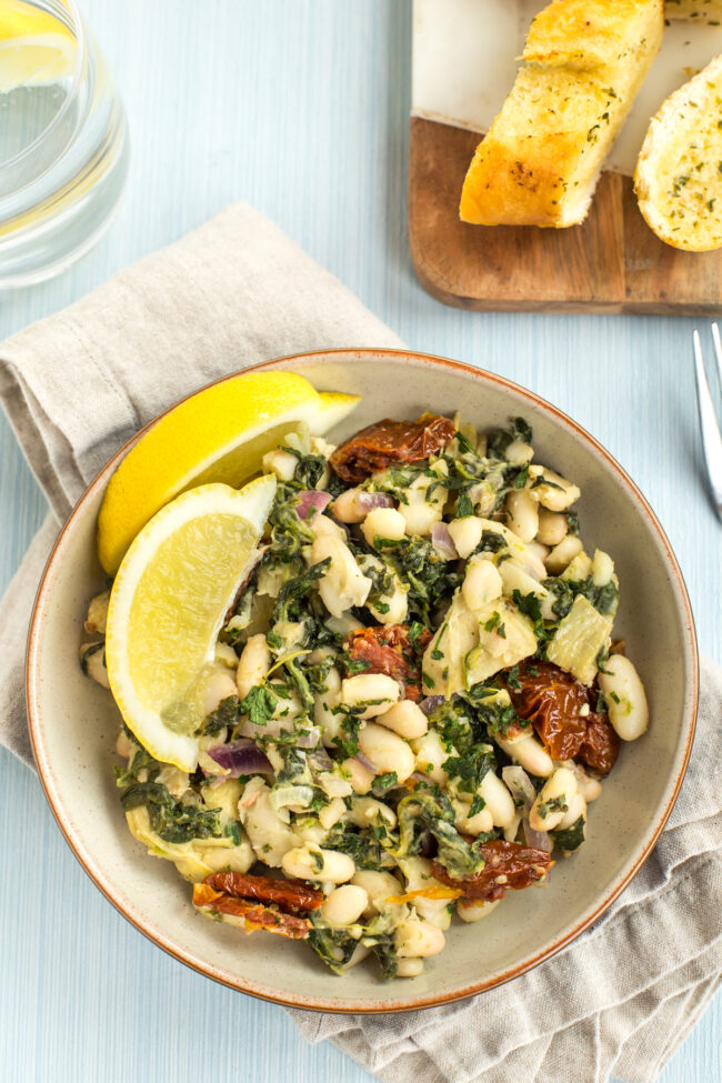 Tuscan beans served with lemon wedges and garlic bread.