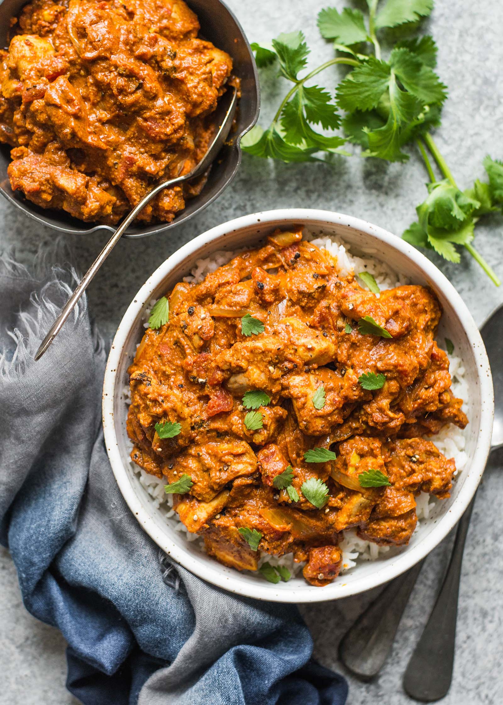 Chicken Tikka Masala Recipe in a bowl with rice and cilantro sprigs