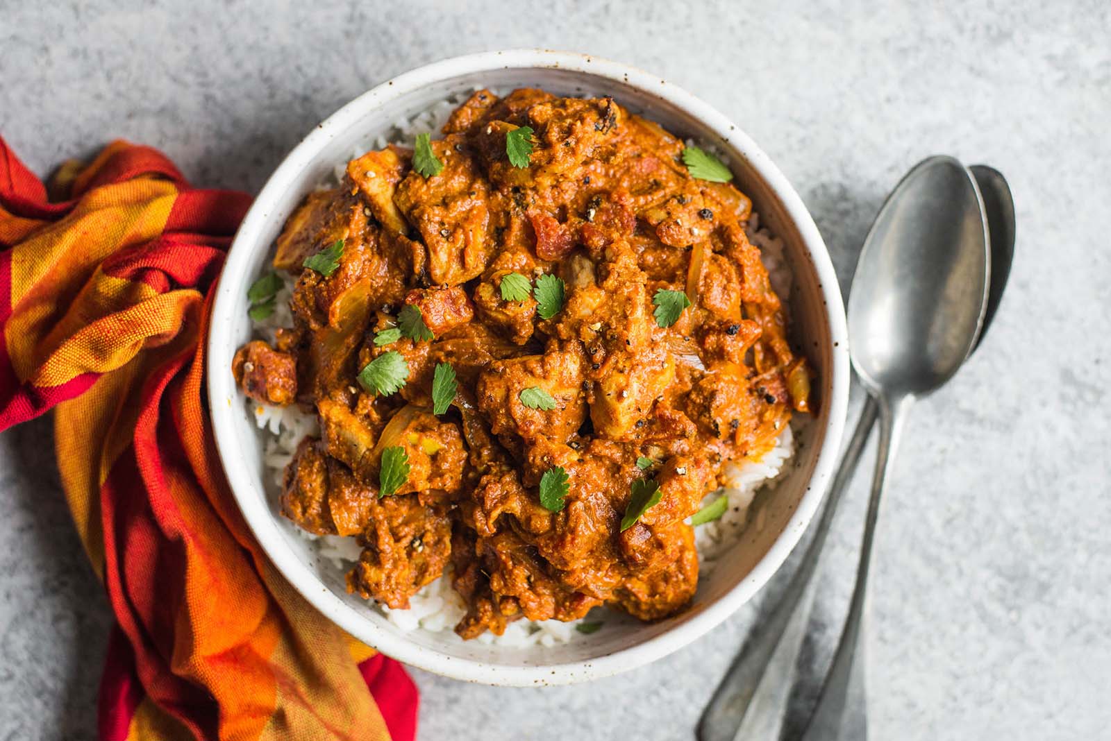 Chicken Tikka Masala finished dish in a bowl with spoons and rice.