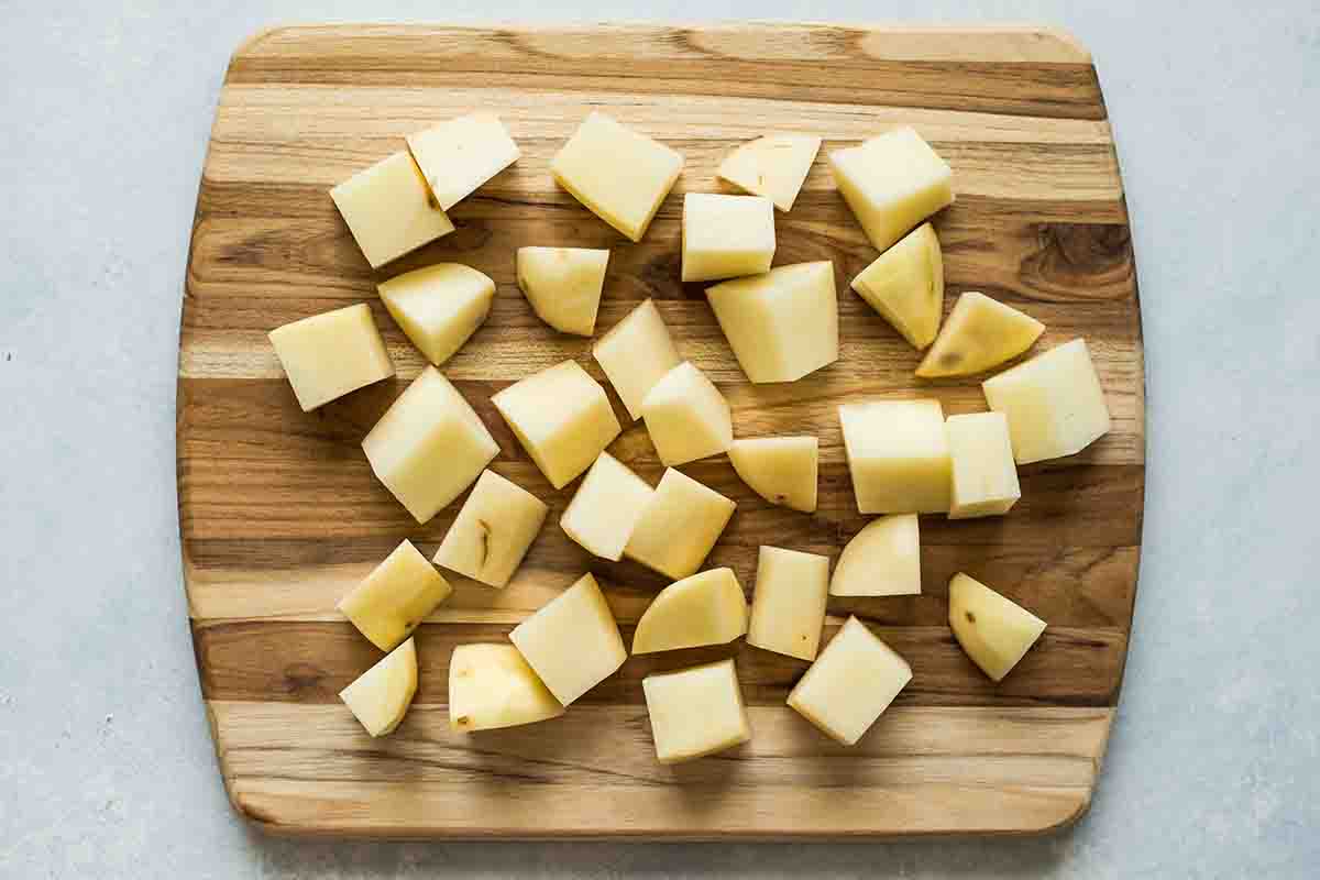 Slow Cooker Mashed Potatoes diced potatoes on a cutting board