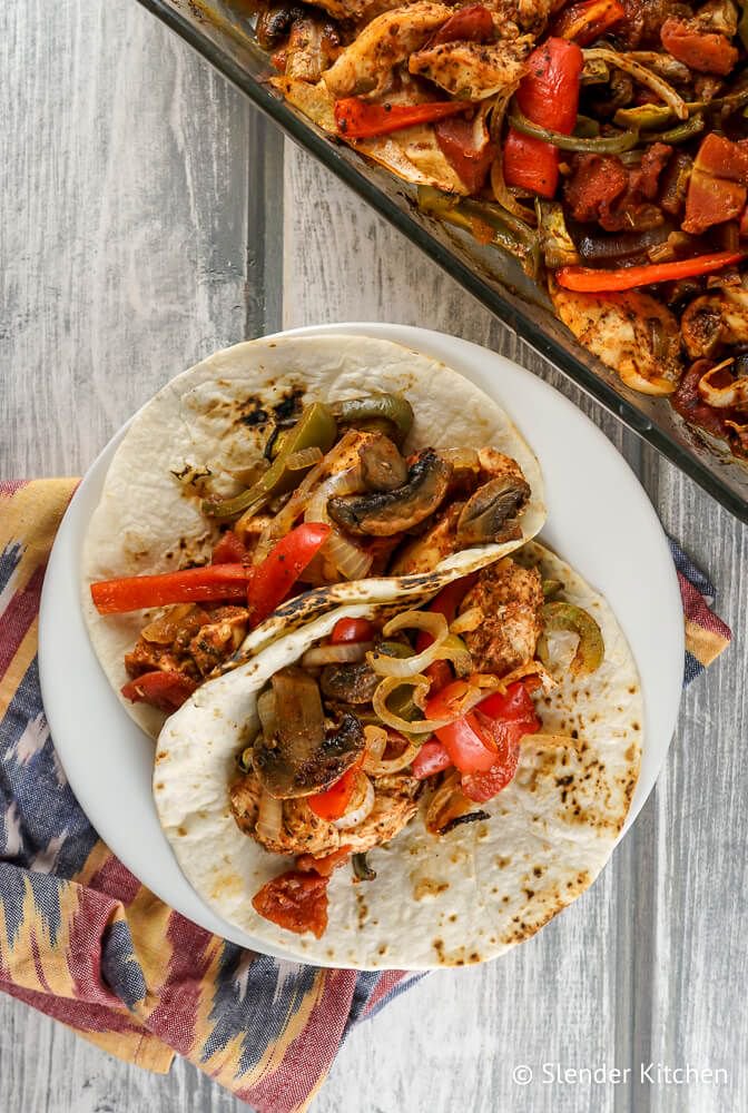Oven baked chicken fajitas in two flour tortillas with peppers, onions, and mushrooms.