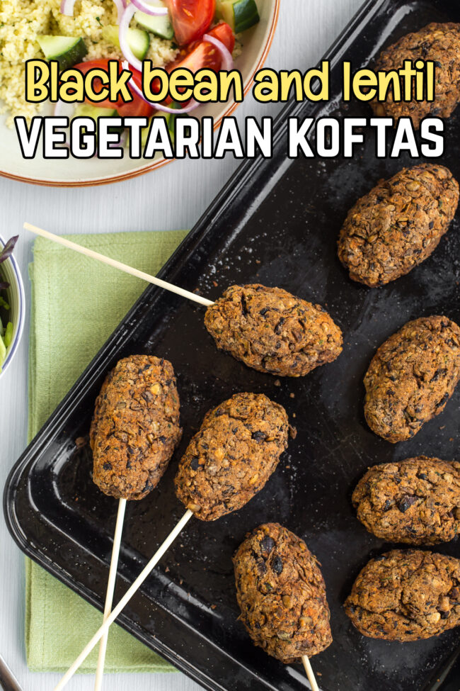 Vegetarian koftas on sticks, laid out on a baking tray.
