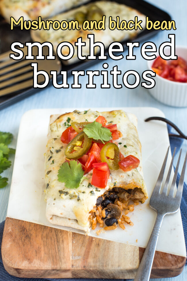 A vegetarian smothered burrito topped with tomatoes and jalapenos, with a scoop removed.