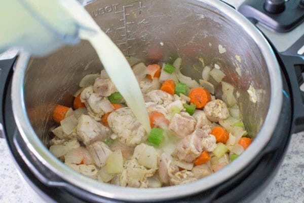Pour broth into an instant pot for the best chicken and dumplings.