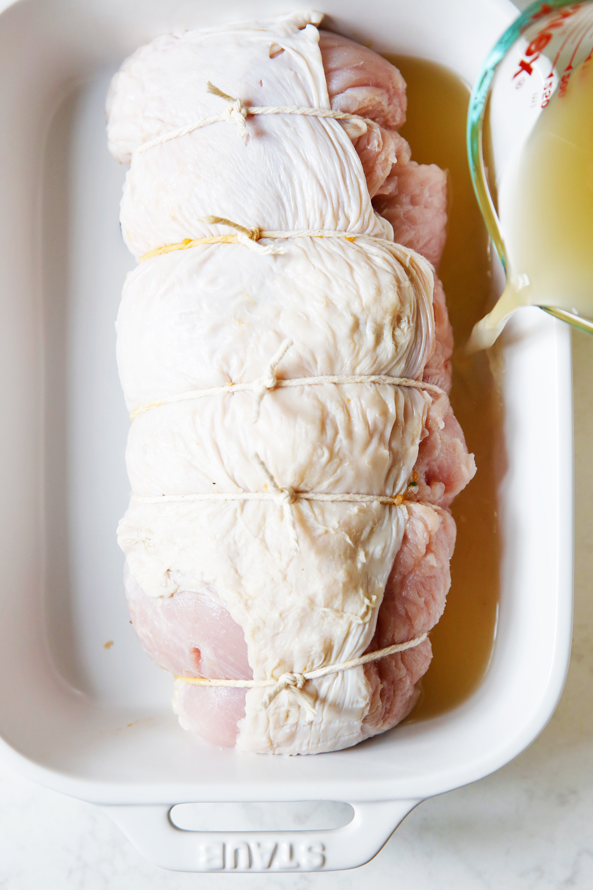 turkey breast stuffed and rolled up in a roasting pan