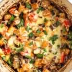 Cheesy Mexican bean and potato bake in a large casserole dish topped with cilantro and shot from above.