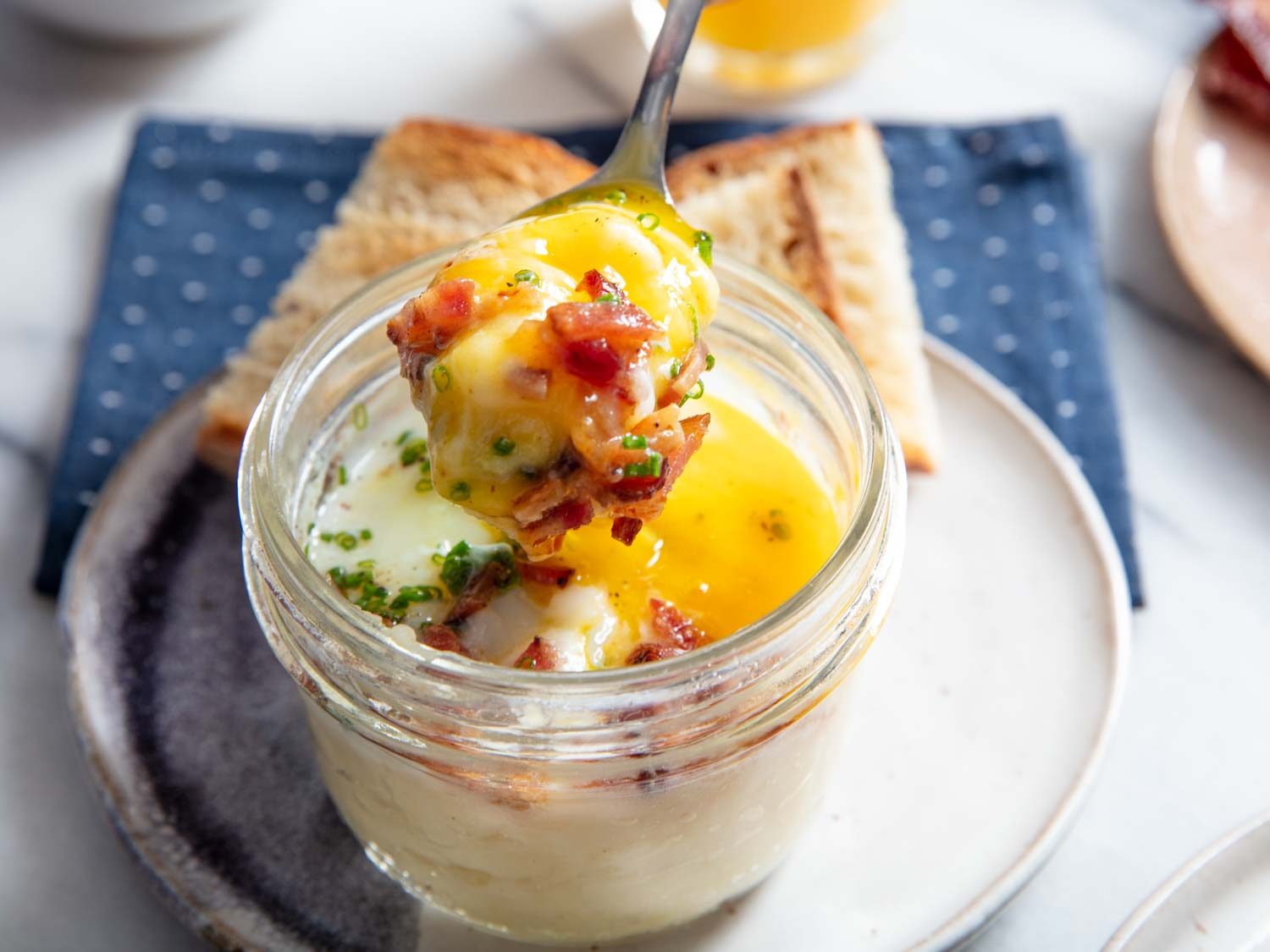 Closeup of a spoonful of potato and egg with crispy chopped bacon.