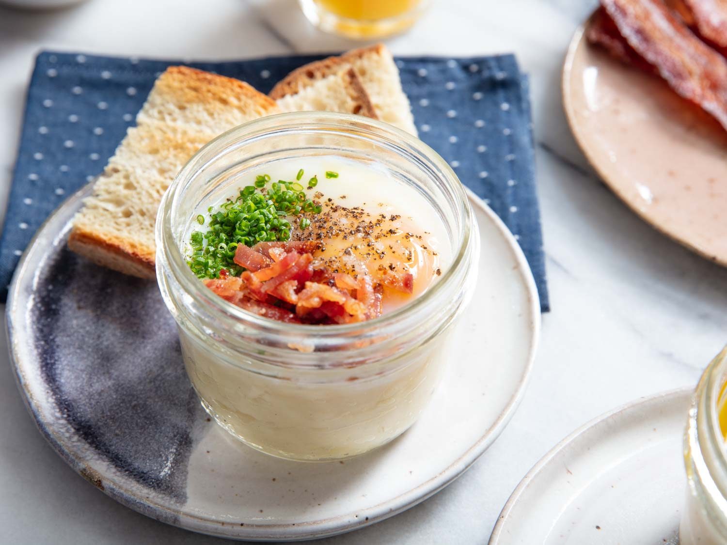 Side view of a potato-egg jar with added chopped crispy bacon.