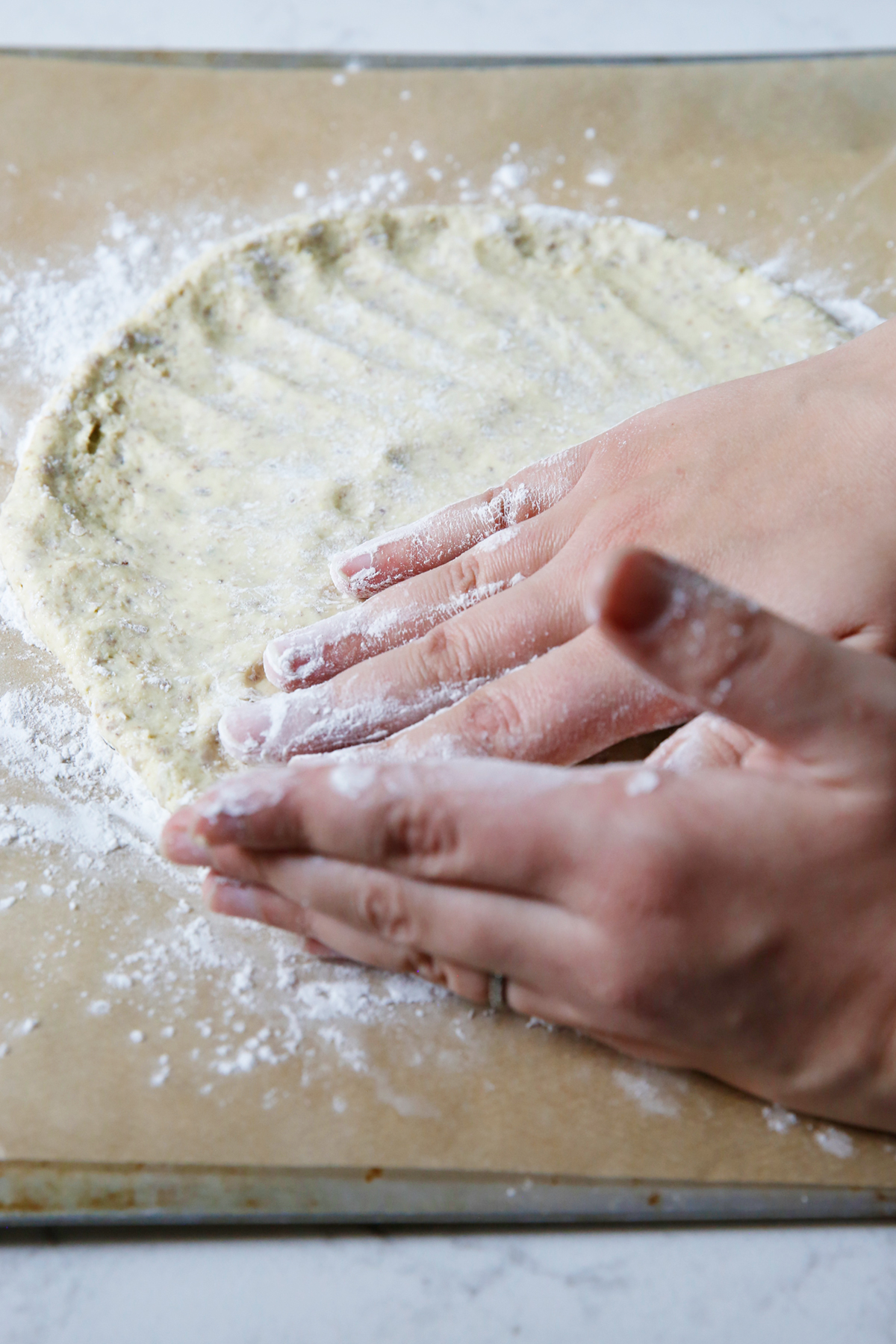 Patting out gluten free pizza dough