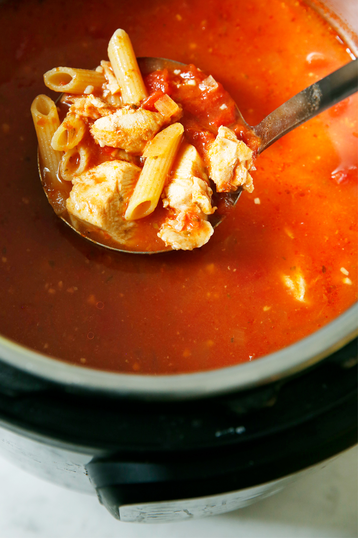 Instant pot chicken parm soup with a ladle