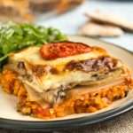 A portion of vegetarian moussaka on a plate served with rocket.