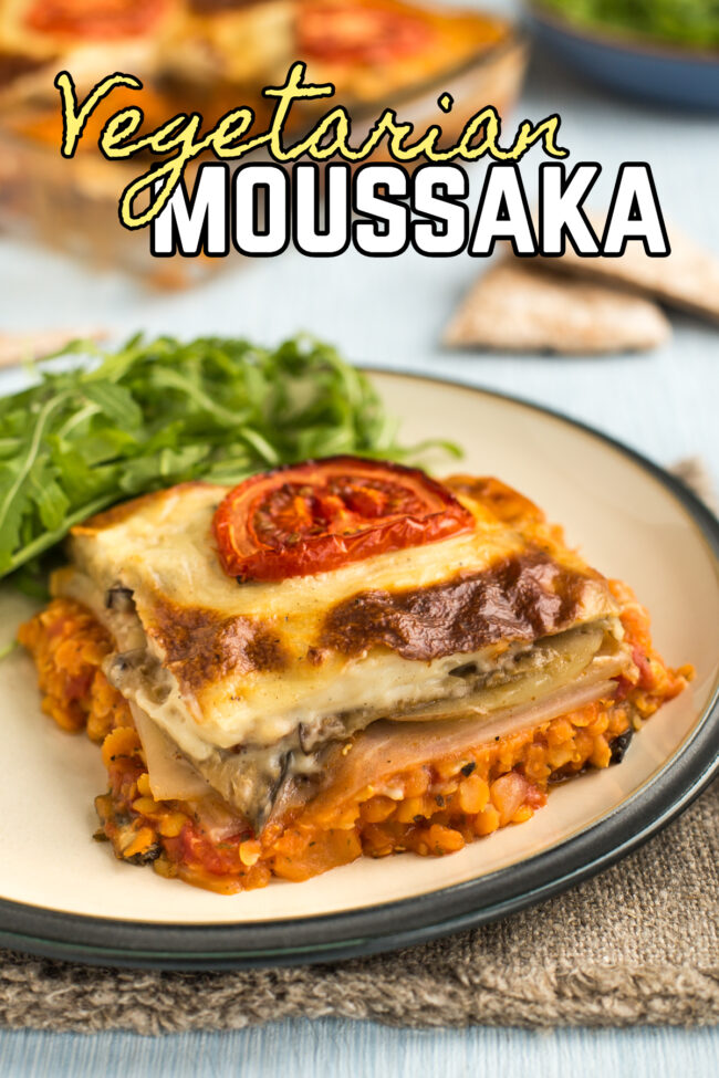 Portion of vegetarian moussaka on a plate, topped with sliced tomato.