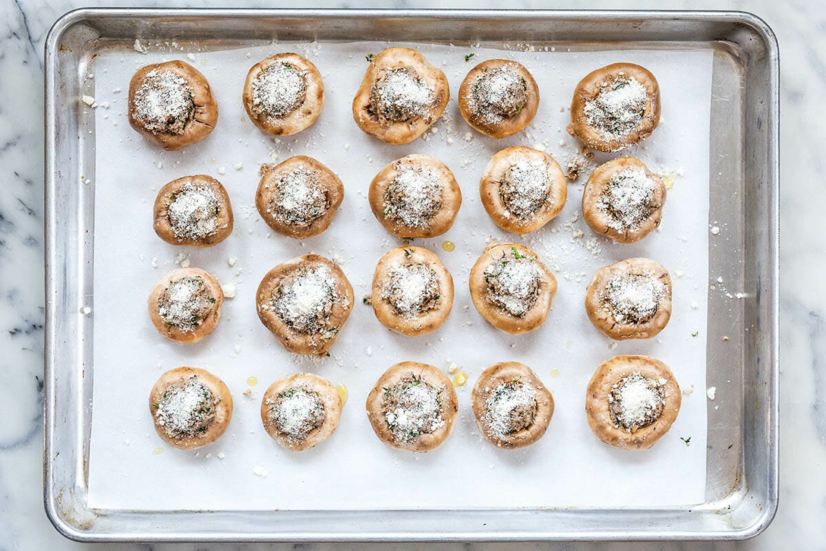 stuffed mushroom caps on a baking sheet ready for baking