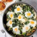 Green Shakshuka in a skillet with crispy latkes alongside