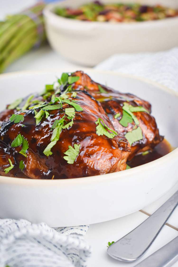 Broiled barbecue chicken thighs in homemade sweet and spicy sauce with a salad.