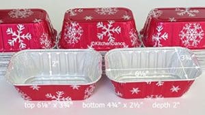 A set of red and white foil baking pans with snowflakes on them.